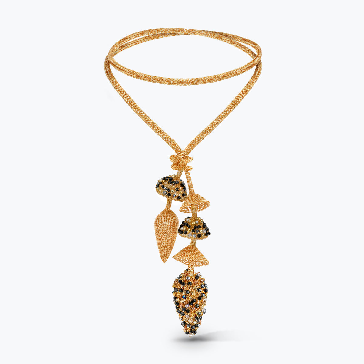 A gold-toned beaded necklace with a double-strand braided cord and a long dangle pendant featuring textured gold, black, and clear crystal elements, shown on a light gray background.
