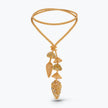 A gold-toned statement necklace featuring a double-strand chain and a dangle pendant with textured leaf and mushroom-like elements, set against a clean white background.