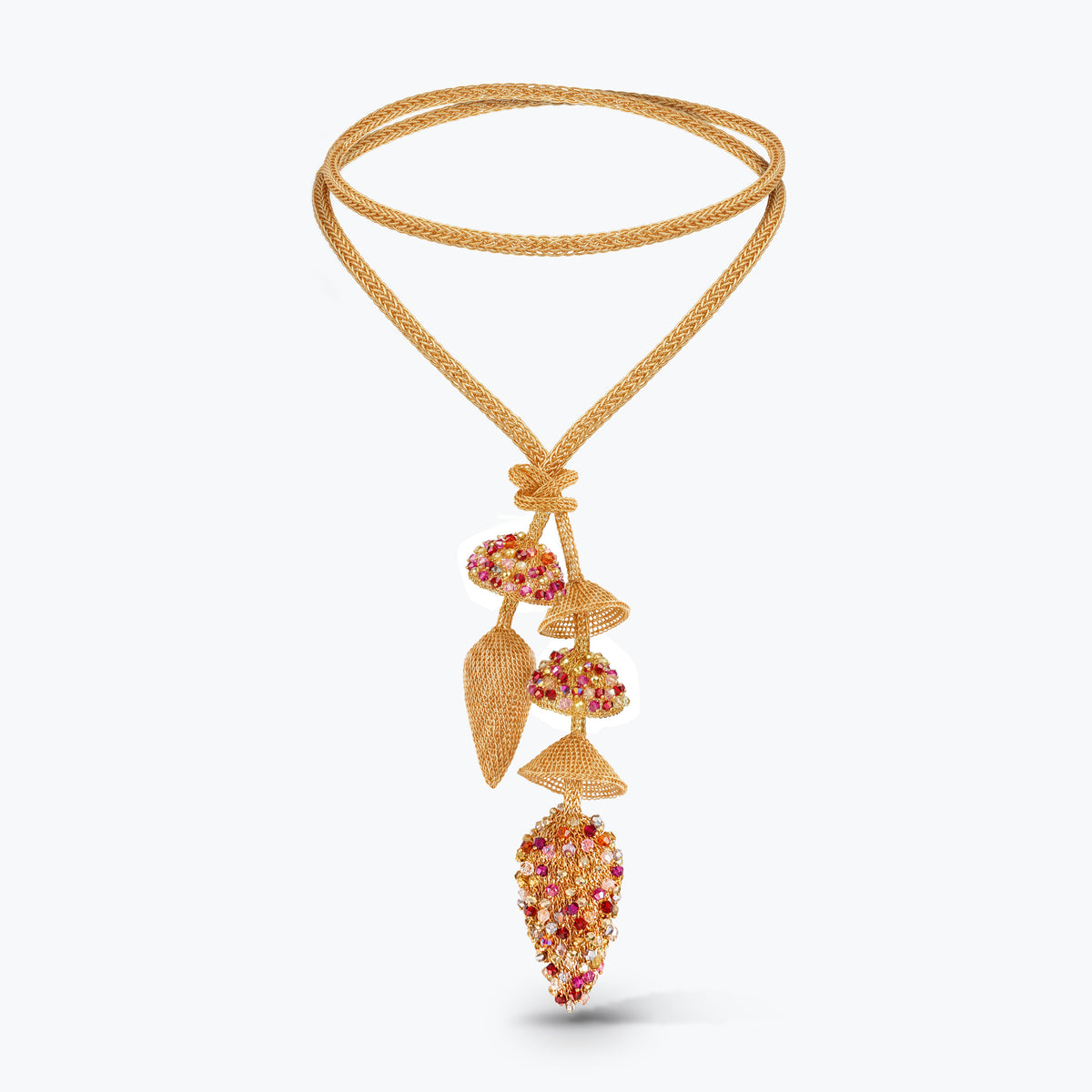 A gold-toned double-strand necklace featuring a botanical pendant with textured leaves and clusters of red and clear stones, displayed on a clean white background.