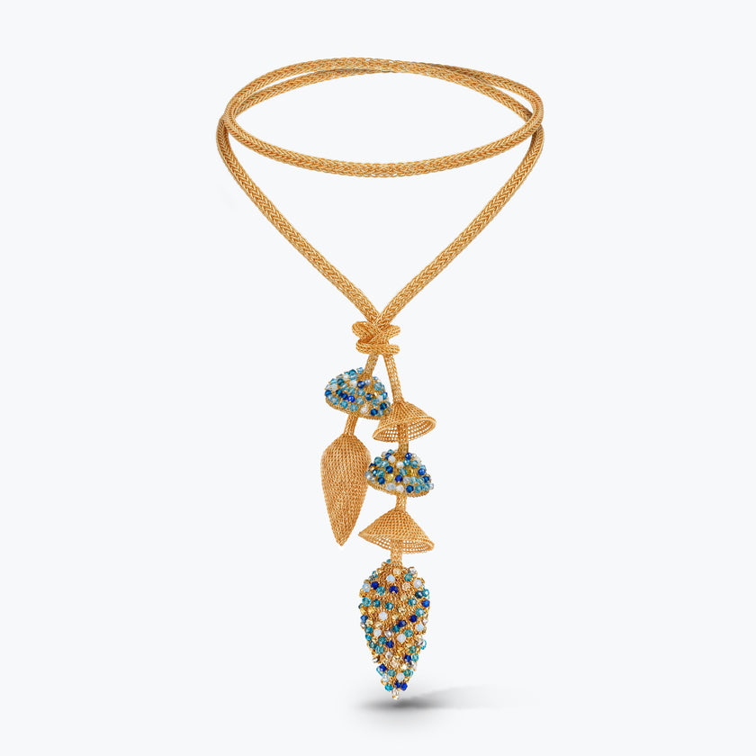 A gold beaded necklace with a double-strand braided cord and a dangle pendant featuring blue, yellow, and gold beads, set against a light gray background.